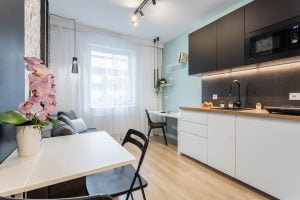 salon z aneksem kuchennym mały biało czarna błękitne elementy minimalistyczna aranżacja Beata Kołodziejczyk