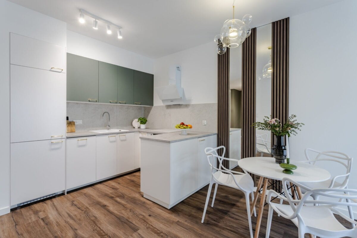 salon z aneksem kuchennym biały szałwia zielony ciemna podłoga lamele lustra białe meble Jak zarabiać na flipie minimalistyczny aranżacja Beata Kołodziejczyk