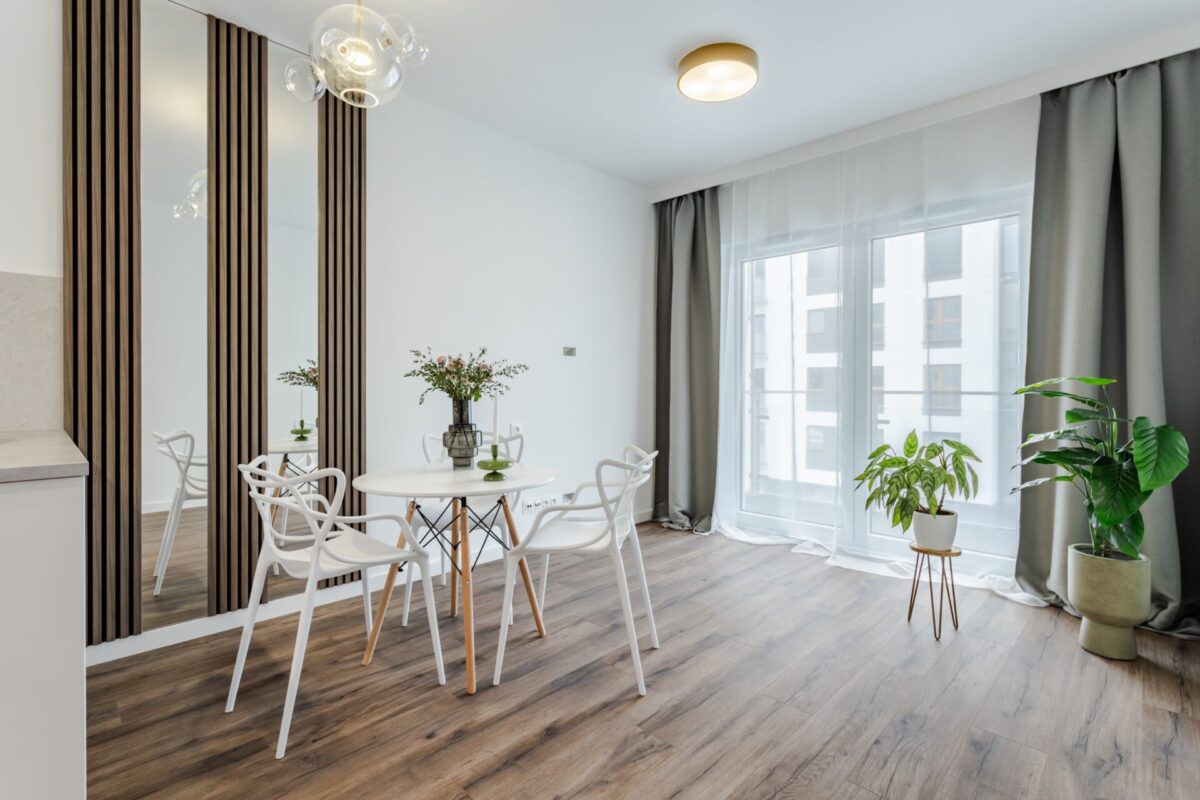 salon z aneksem kuchennym średni popielaty brąz ciemna podłoga lamele lustra minimalistyczny aranżacja Beata Kołodziejczyk